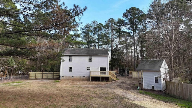 rear view of property with crawl space, a wooden deck, and fence