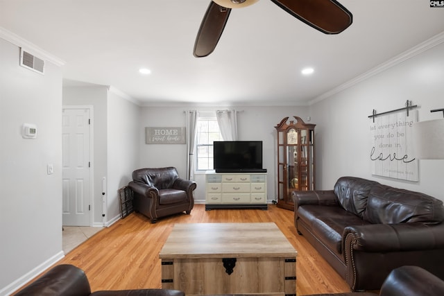 living area with crown molding, light wood-type flooring, visible vents, and ceiling fan