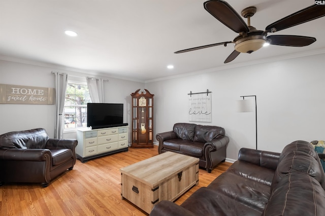 living area with crown molding, light wood-style floors, and a ceiling fan