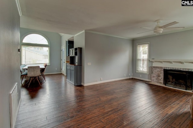 unfurnished living room featuring dark wood-style floors, visible vents, a fireplace, ceiling fan, and crown molding