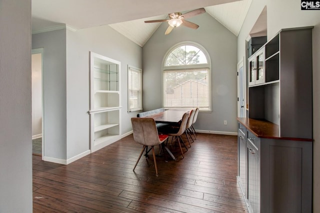 dining room featuring built in shelves, dark wood-style floors, baseboards, ceiling fan, and vaulted ceiling