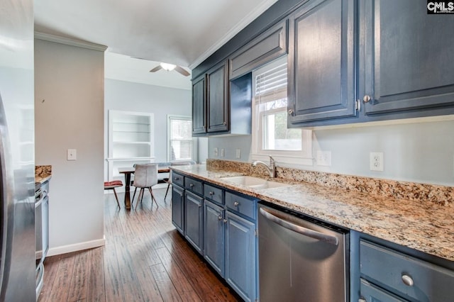 kitchen with blue cabinets, a ceiling fan, a sink, stainless steel appliances, and dark wood-style flooring