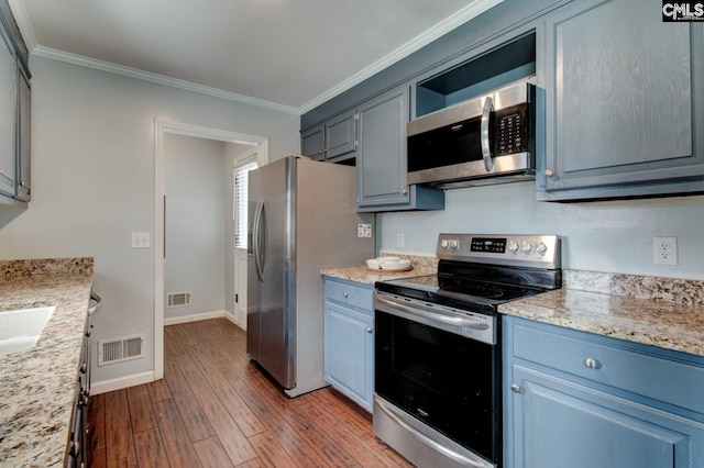 kitchen featuring dark wood finished floors, visible vents, appliances with stainless steel finishes, and ornamental molding