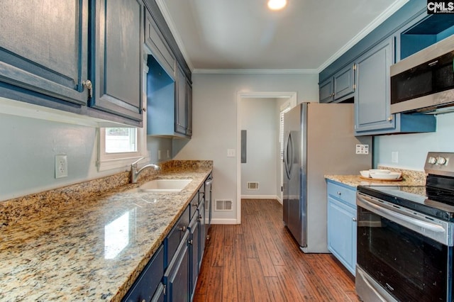 kitchen with ornamental molding, a sink, blue cabinetry, dark wood finished floors, and stainless steel appliances