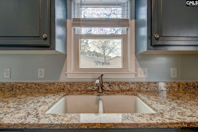 kitchen with a sink, plenty of natural light, and light stone countertops