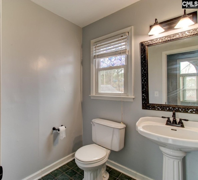 bathroom featuring tile patterned flooring, toilet, and baseboards