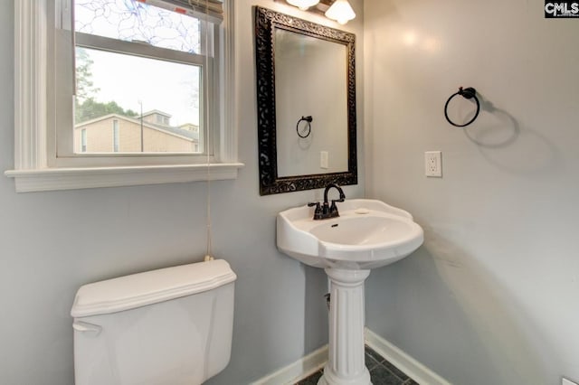 bathroom with toilet and baseboards