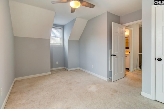 additional living space featuring a ceiling fan, vaulted ceiling, light colored carpet, and baseboards