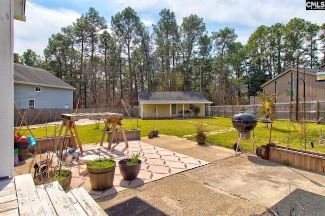 view of patio / terrace featuring an outbuilding, grilling area, and a fenced backyard