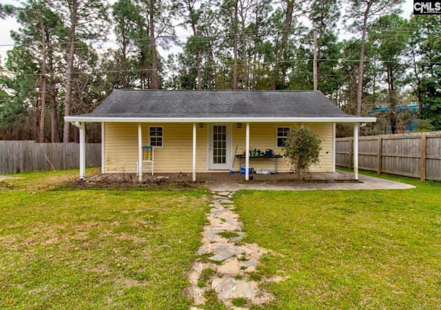 view of front of home with a front yard and fence