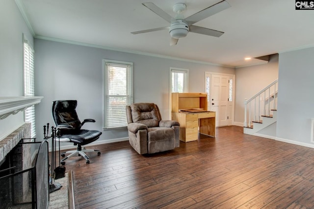 sitting room with a brick fireplace, dark wood-type flooring, baseboards, stairs, and ornamental molding