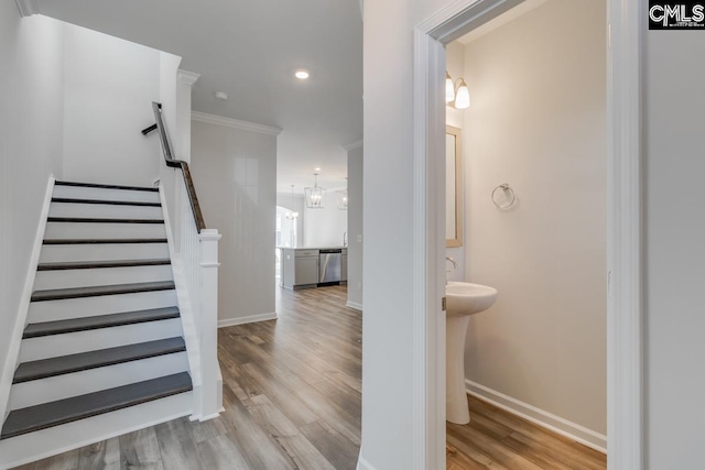 staircase featuring recessed lighting, baseboards, wood finished floors, and ornamental molding