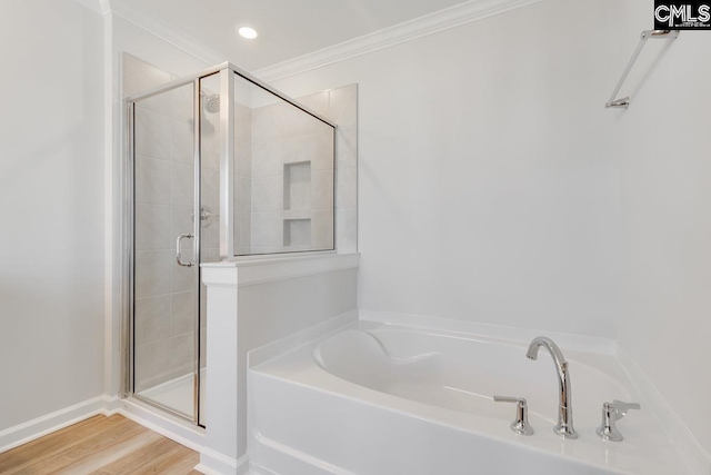 full bathroom with a stall shower, crown molding, a garden tub, and wood finished floors