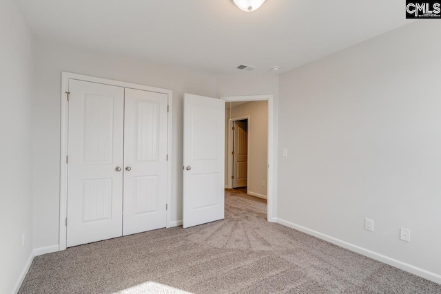 unfurnished bedroom with a closet, visible vents, baseboards, and carpet floors