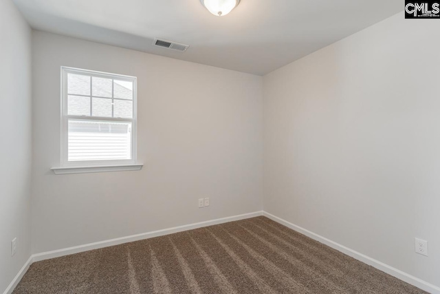 carpeted spare room featuring baseboards and visible vents