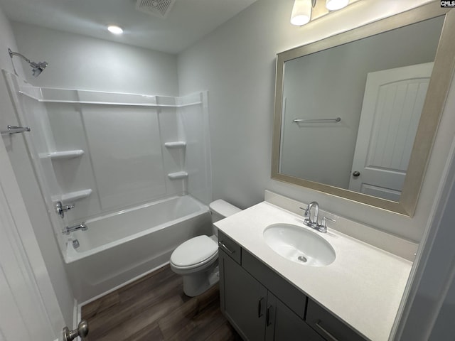 bathroom featuring visible vents, toilet, wood finished floors, tub / shower combination, and vanity