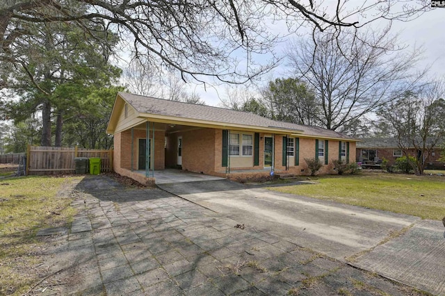 ranch-style house featuring brick siding, a front lawn, fence, concrete driveway, and a carport