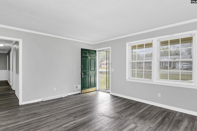 unfurnished room featuring a textured ceiling, dark wood-style floors, baseboards, and ornamental molding