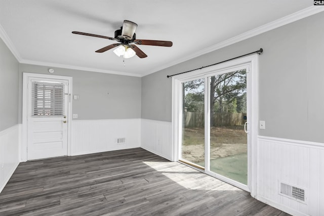 unfurnished room with visible vents, wainscoting, ceiling fan, and dark wood-style flooring