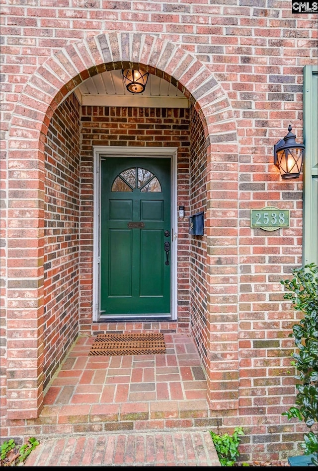 entrance to property featuring brick siding