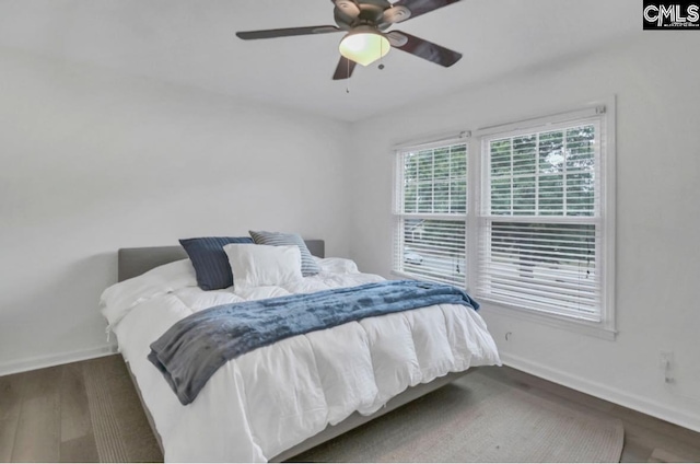 bedroom featuring a ceiling fan, baseboards, and wood finished floors