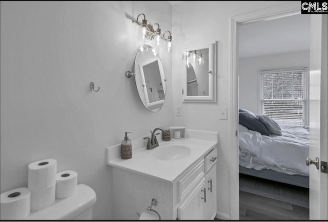 ensuite bathroom featuring toilet, ensuite bath, and vanity