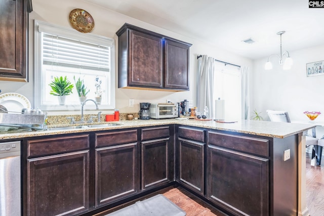 kitchen featuring visible vents, stainless steel dishwasher, a peninsula, light stone countertops, and dark brown cabinets