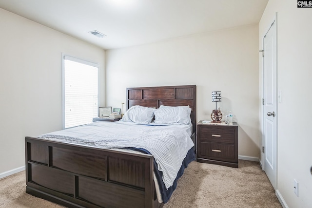 bedroom with light carpet, visible vents, and baseboards