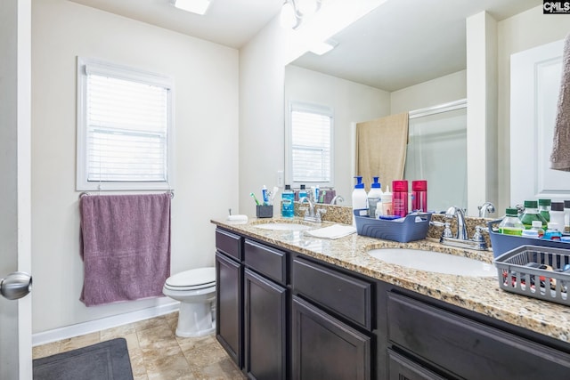 full bathroom with a sink, a shower with door, toilet, and double vanity