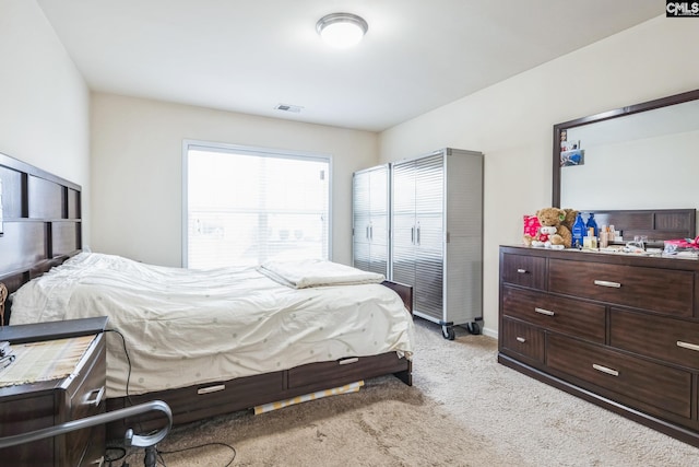 bedroom with visible vents and light carpet