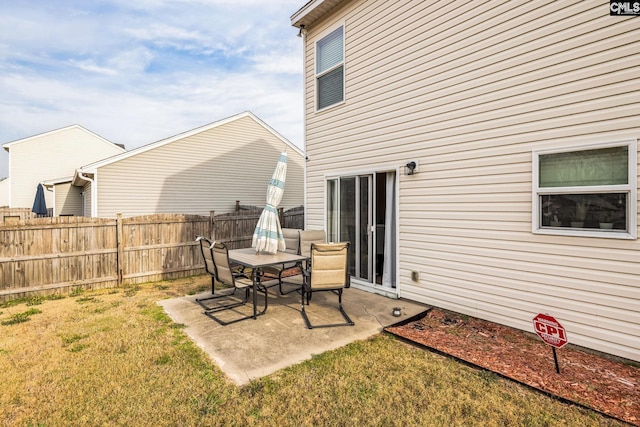 rear view of house with a patio, fence, and a lawn