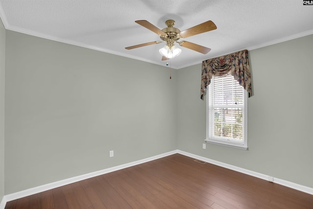 empty room featuring visible vents, ornamental molding, a textured ceiling, dark wood finished floors, and baseboards