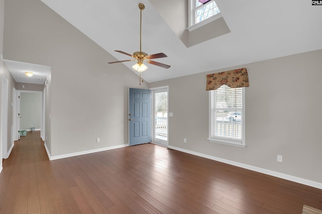 unfurnished living room with high vaulted ceiling, a ceiling fan, wood finished floors, baseboards, and attic access