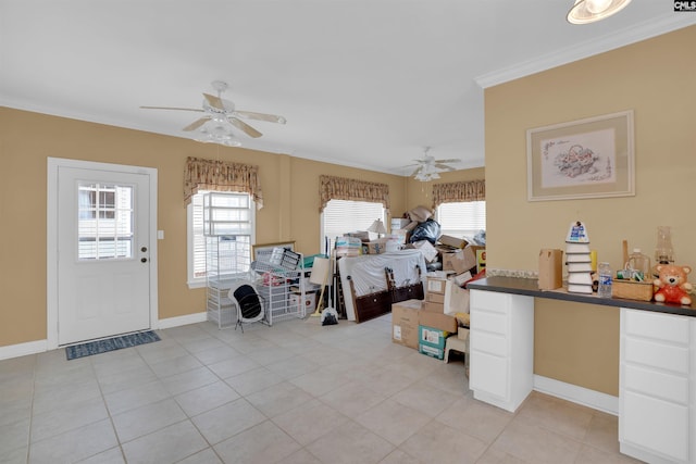 interior space with light tile patterned floors, baseboards, ceiling fan, and ornamental molding