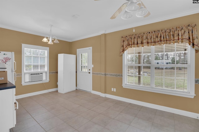 unfurnished dining area featuring cooling unit, baseboards, ornamental molding, and ceiling fan with notable chandelier