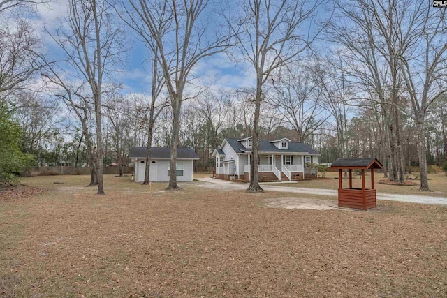 view of front facade featuring an outbuilding, a garage, and covered porch