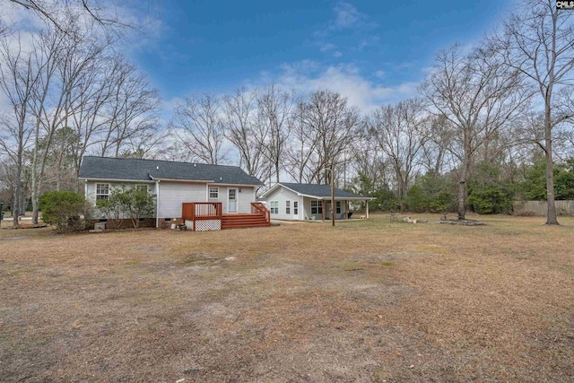 back of house with a lawn, a deck, and fence