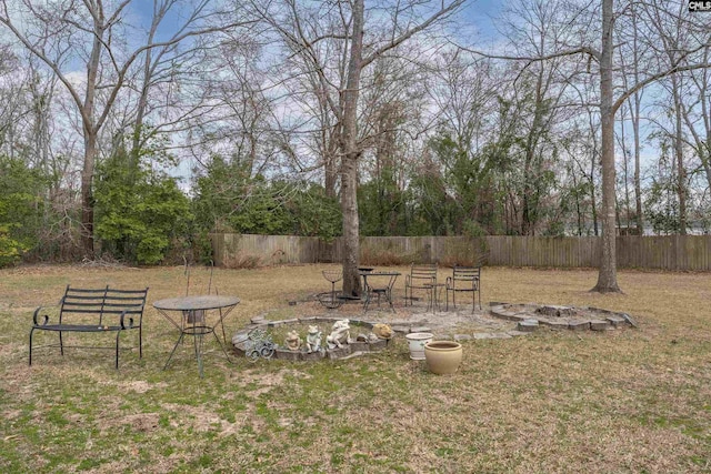 view of yard featuring an outdoor fire pit and fence