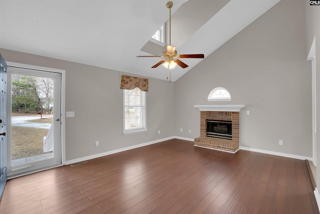 unfurnished living room with baseboards, high vaulted ceiling, dark wood-style flooring, ceiling fan, and a brick fireplace