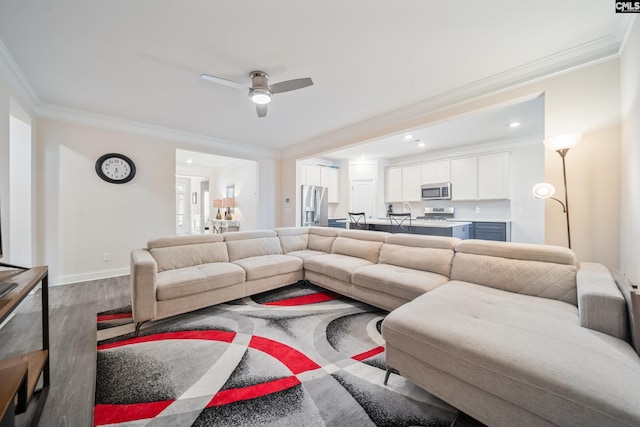 living room featuring ornamental molding, wood finished floors, recessed lighting, baseboards, and ceiling fan