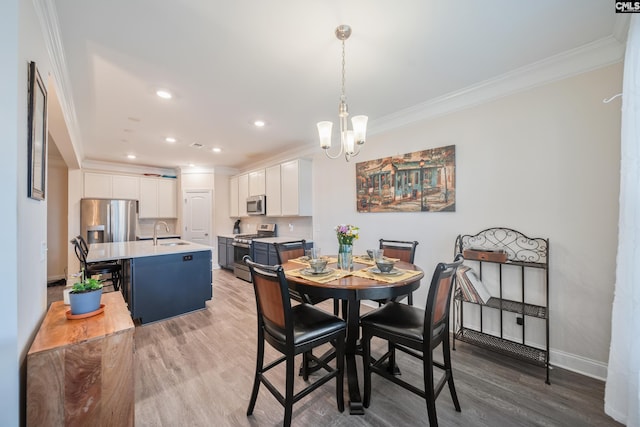 dining area featuring wood finished floors, baseboards, recessed lighting, crown molding, and a notable chandelier