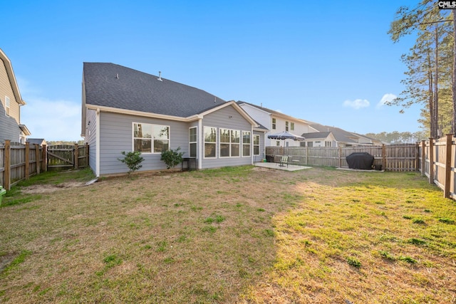 back of house with a yard, roof with shingles, a fenced backyard, and a patio area