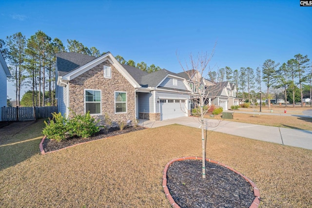 view of front of property with fence, concrete driveway, a front yard, a garage, and stone siding