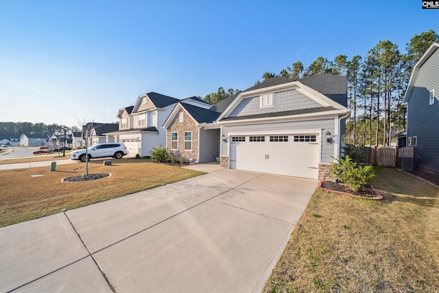 view of front of house featuring a front lawn, fence, a garage, stone siding, and driveway