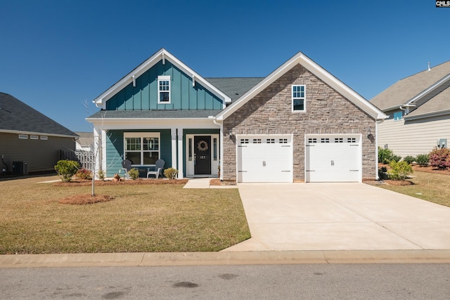 craftsman-style home featuring board and batten siding, a front lawn, concrete driveway, covered porch, and an attached garage