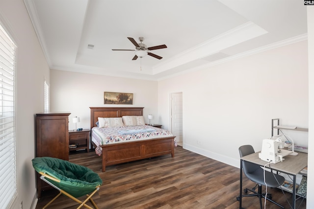 bedroom with crown molding, baseboards, a tray ceiling, dark wood-style floors, and a ceiling fan