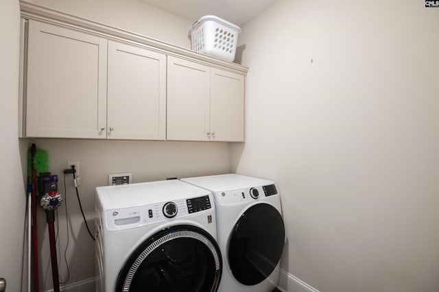 laundry area featuring cabinet space, baseboards, and washer and clothes dryer