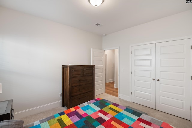 unfurnished bedroom with baseboards, visible vents, a closet, and light carpet