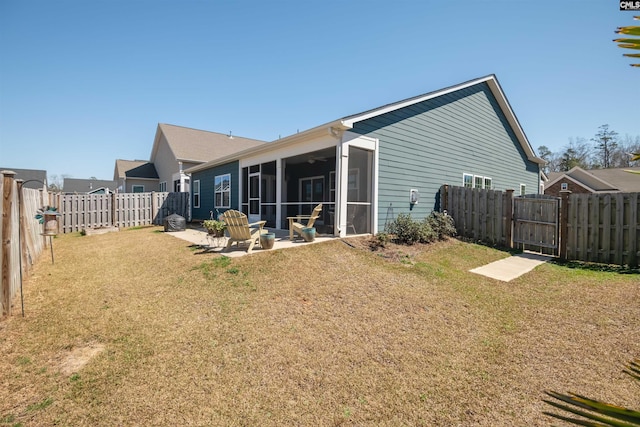 rear view of house with a lawn, a patio, a fenced backyard, and a sunroom