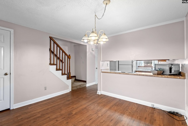 interior space featuring wood finished floors, baseboards, stairs, a textured ceiling, and a notable chandelier